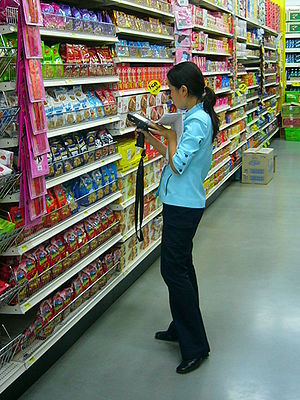 English: Female clerk doing inventory work usi...